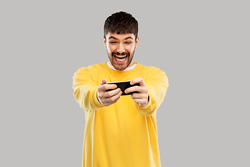 Image showing happy laughing young man with smartphone