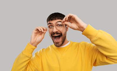 Image showing goofy young man in glasses and yellow sweatshirt