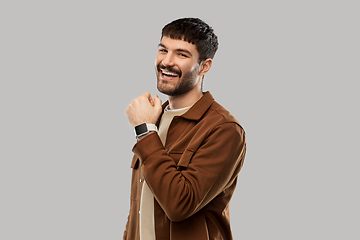 Image showing smiling young man with smart watch