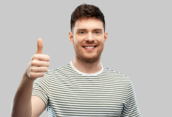 Image showing smiling young man showing thumbs up