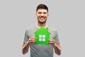 Image showing smiling young man holding green house icon