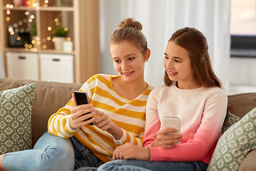 Image showing happy teenage girls with smartphones at home