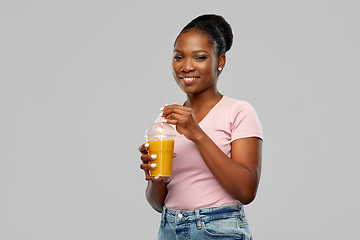 Image showing happy african american woman drinking orange juice