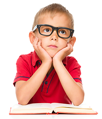 Image showing Little boy is reading a book