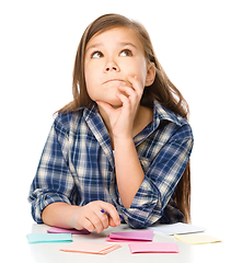 Image showing Girl is writing on color stickers using pen