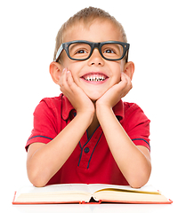 Image showing Little boy is reading a book