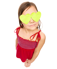 Image showing Little girl is holding hearts over her eyes