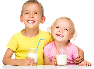 Image showing Cute little girl and boy are drinking milk