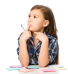 Image showing Girl is writing on color stickers using pen
