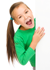 Image showing Little girl is looking from out blank board