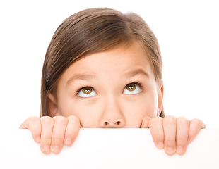 Image showing Little girl is looking from out blank board