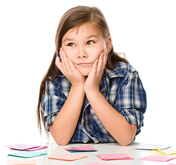 Image showing Girl is writing on color stickers using pen