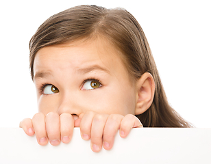 Image showing Little girl is looking from out blank board