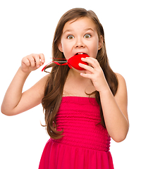 Image showing Portrait of a little girl biting red heart