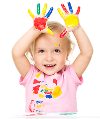 Image showing Portrait of a cute little girl playing with paints