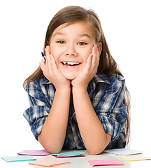 Image showing Girl is writing on color stickers using pen