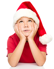 Image showing Little girl in santa hat is daydreaming