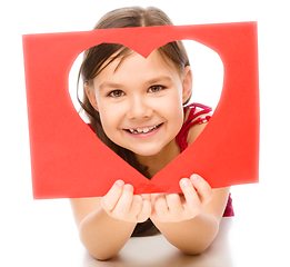 Image showing Little girl is looking through heart template