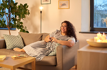 Image showing happy woman drinking red wine at home in evening