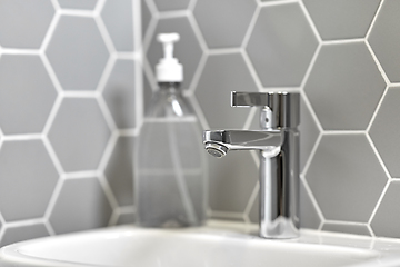 Image showing close up of water tap with liquid soap on sink