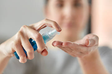 Image showing close up of woman spraying hand sanitizer