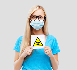 Image showing woman in medical mask with boihazard caution sign