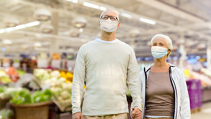 Image showing senior couple in medical masks at supermarket