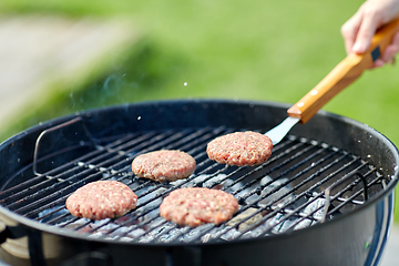 Image showing close up of meat cutlets roasting on grill