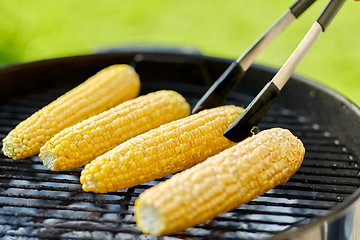 Image showing close up of corn roasting on grill outdoors