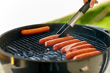 Image showing meat sausages roasting on hot brazier grill