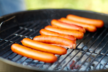 Image showing meat sausages roasting on hot brazier grill