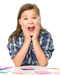 Image showing Girl is writing on color stickers using pen