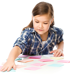 Image showing Girl is writing on color stickers using pen