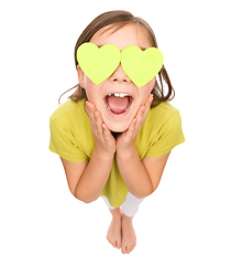 Image showing Little girl is holding hearts over her eyes