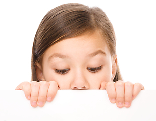 Image showing Little girl is looking from out blank board