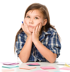 Image showing Girl is writing on color stickers using pen