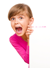 Image showing Little girl is looking out from the blank banner