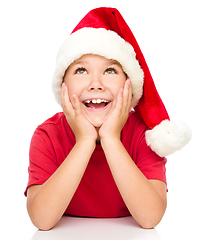 Image showing Little girl in santa hat is daydreaming