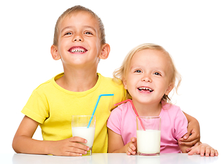 Image showing Cute little girl and boy are drinking milk