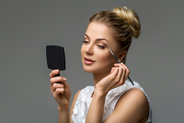 Image showing beautiful girl applying makeup