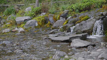 Image showing Big beautiful waterfall flows down the rocks mountains