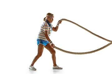 Image showing Senior woman training with ropes in sportwear on white background