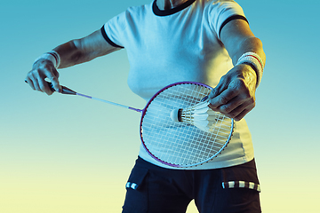 Image showing Senior woman playing badminton in sportwear on gradient background in neon light