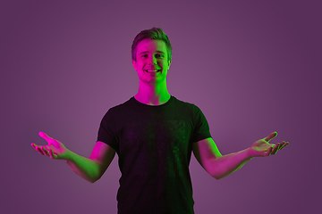 Image showing Caucasian man\'s portrait isolated on purple studio background in neon light