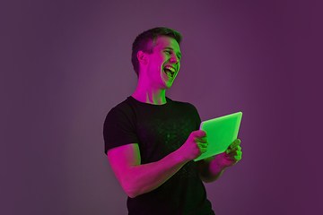 Image showing Caucasian man\'s portrait isolated on purple studio background in neon light