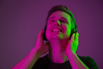 Image showing Caucasian man\'s portrait isolated on purple studio background in neon light