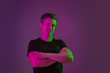 Image showing Caucasian man\'s portrait isolated on purple studio background in neon light