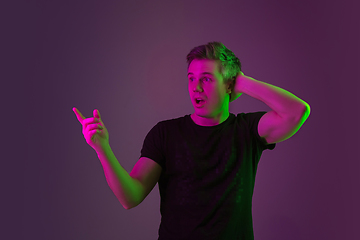 Image showing Caucasian man\'s portrait isolated on purple studio background in neon light