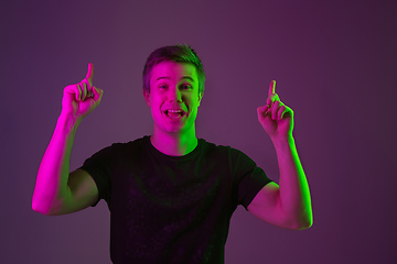 Image showing Caucasian man\'s portrait isolated on purple studio background in neon light