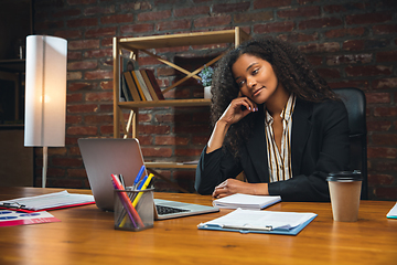 Image showing Young woman working in modern office using devices and gadgets. Making reports, analitycs, routine processing tasks